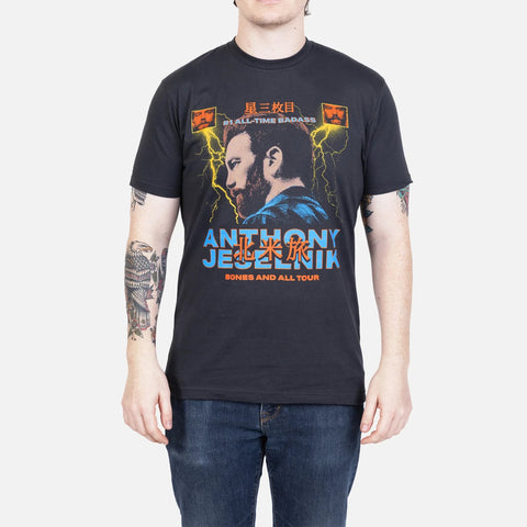 Black shirt on model with graphic of Anthony Jeselnik surrounded by lighting bolts and text "#1 ALL-TIME BADASS ANTHONY JESELNIK BONES AND ALL TOUR"